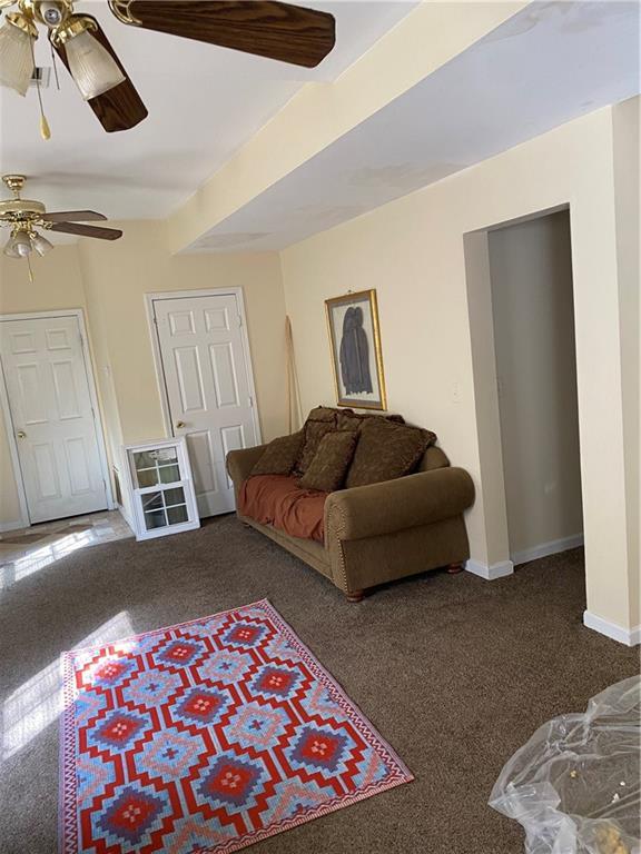 carpeted living room featuring ceiling fan