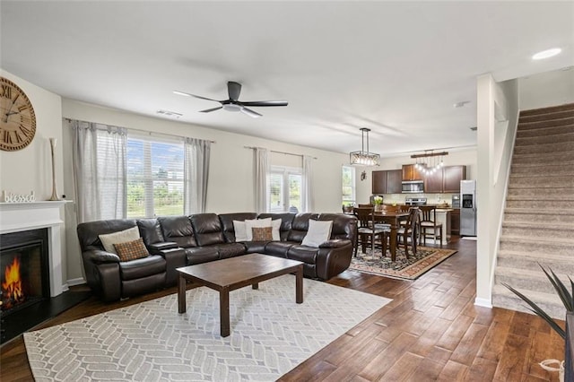 8553 Braylen Manor Dr, Douglasville, GA 30134 - living room featuring stairway, dark wood-style floors, a glass covered fireplace, and ceiling fan