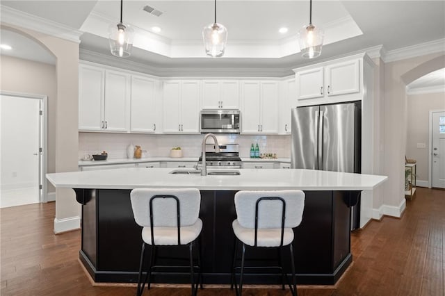 kitchen with a center island with sink, dark hardwood / wood-style floors, white cabinetry, and appliances with stainless steel finishes