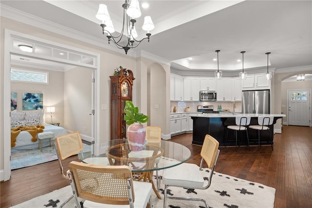 dining room with a notable chandelier, plenty of natural light, and dark hardwood / wood-style flooring