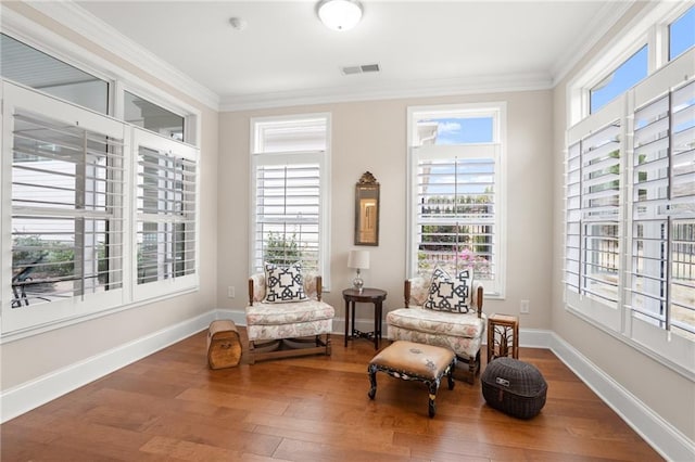 living area featuring crown molding and hardwood / wood-style flooring