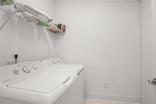 washroom featuring washing machine and dryer and light tile patterned floors