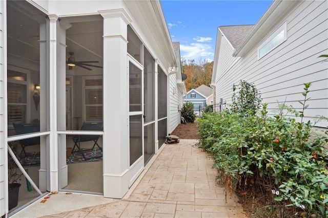 view of side of home featuring a sunroom and a patio