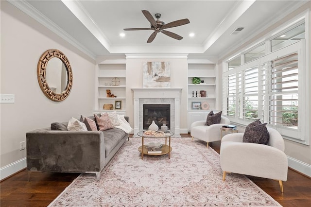 living room featuring ceiling fan, crown molding, dark wood-type flooring, and a high end fireplace