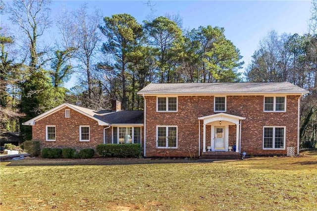 colonial house featuring a front lawn