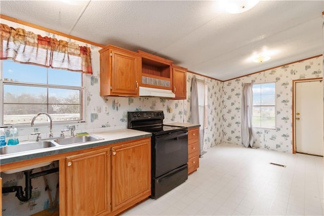 kitchen with under cabinet range hood, black electric range oven, a sink, and wallpapered walls