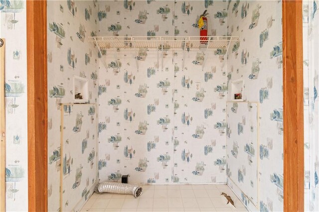 bathroom with wallpapered walls and tile patterned floors