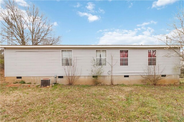 back of property featuring a yard, crawl space, and cooling unit