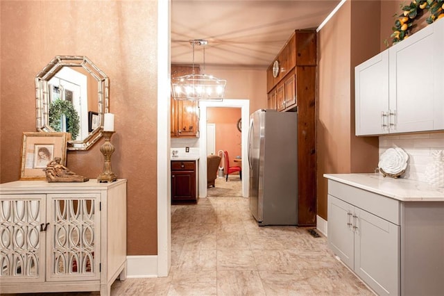 791 E Main St, Canton, GA 30114 - kitchen with freestanding refrigerator, decorative backsplash, light countertops, and decorative light fixtures