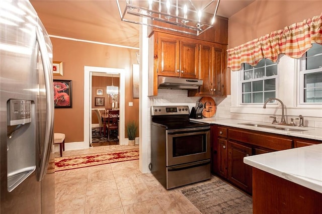 791 E Main St, Canton, GA 30114 - kitchen with stainless steel appliances, under cabinet range hood, a sink, a chandelier, and light countertops