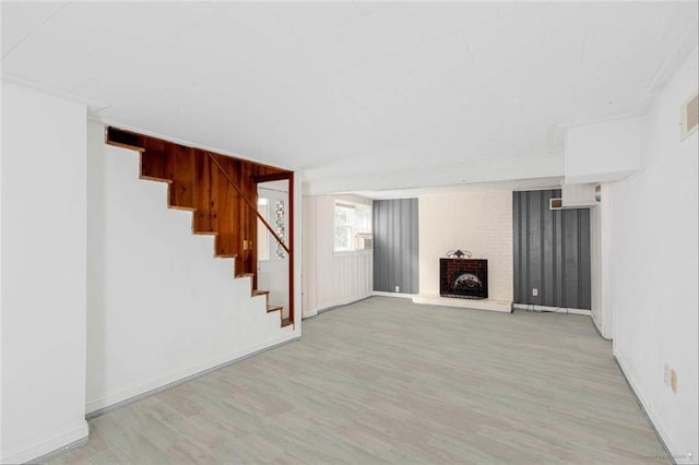 791 E Main St, Canton, GA 30114 - unfurnished living room with wood finished floors, a brick fireplace, stairs, and baseboards