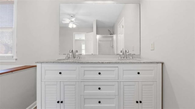 bathroom with a ceiling fan, a stall shower, a sink, and double vanity