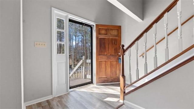 entrance foyer featuring stairs, baseboards, and wood finished floors