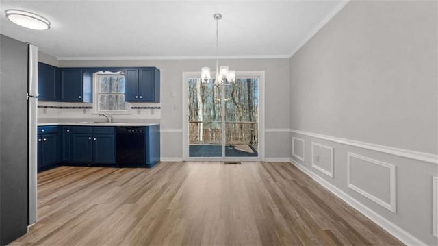 kitchen featuring black dishwasher, freestanding refrigerator, blue cabinets, an inviting chandelier, and light countertops