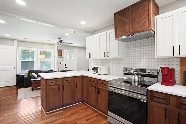 1202 Key Rd SE, Atlanta, GA 30316 - kitchen featuring stainless steel electric range, wall chimney exhaust hood, white microwave, a peninsula, and light countertops