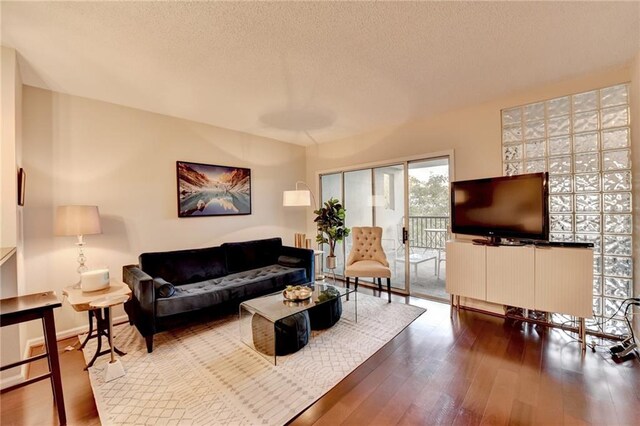 living room with wood-type flooring and a textured ceiling