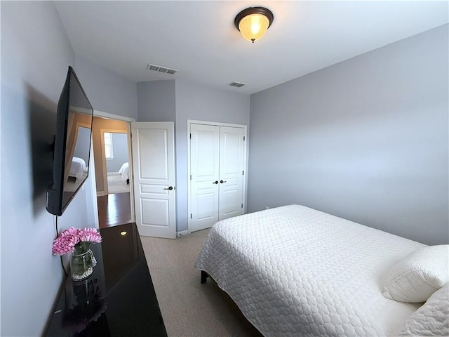 carpeted bedroom featuring a closet and visible vents