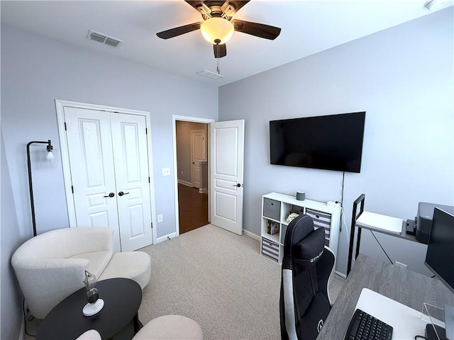 office space with ceiling fan, carpet flooring, baseboards, and visible vents