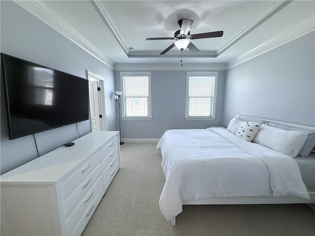 bedroom featuring light colored carpet, a raised ceiling, crown molding, and baseboards