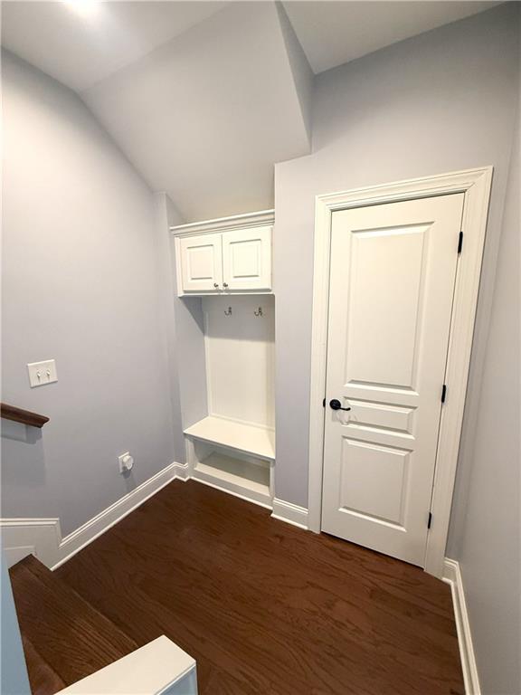 mudroom featuring vaulted ceiling, baseboards, and dark wood finished floors