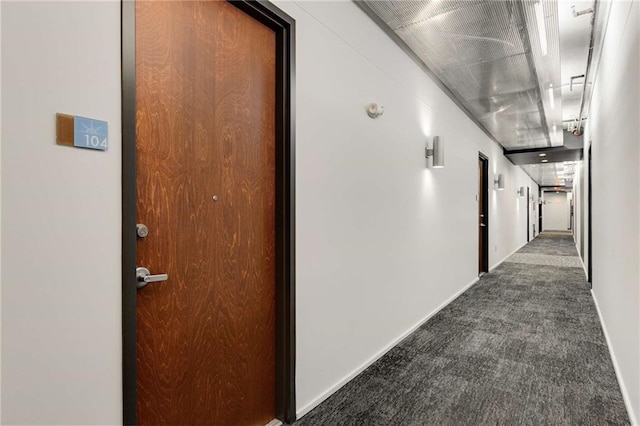 hall featuring dark colored carpet