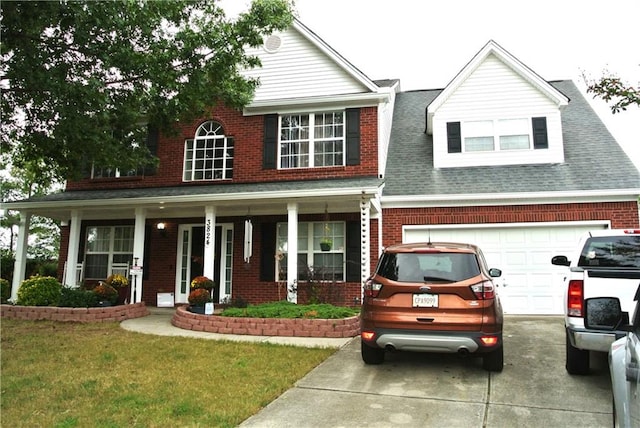 view of front of property with a porch, a garage, and a front yard