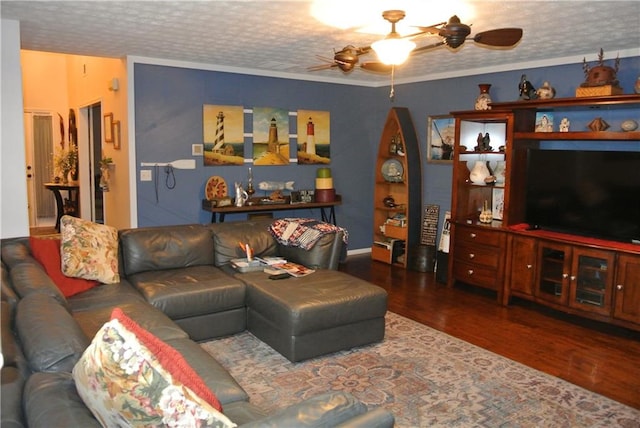 living room featuring ceiling fan, crown molding, dark wood-type flooring, and a textured ceiling