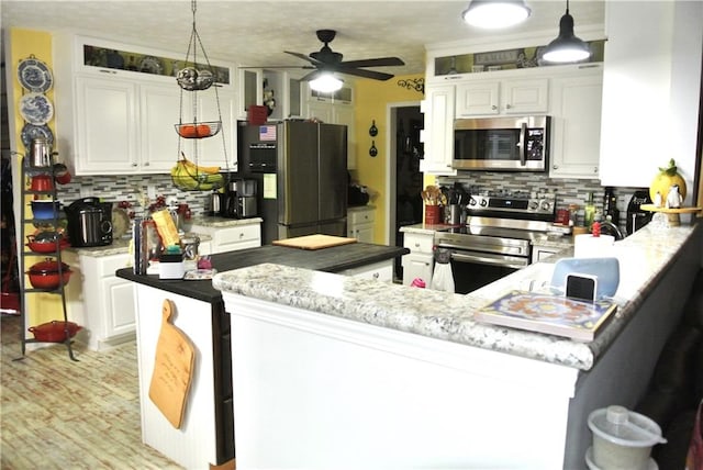 kitchen with white cabinetry, ceiling fan, appliances with stainless steel finishes, and hanging light fixtures