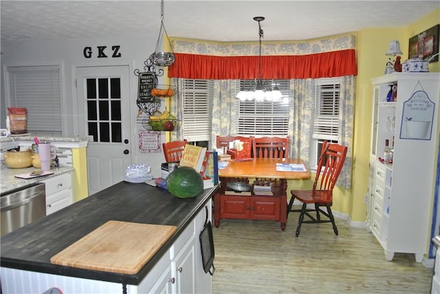 kitchen featuring light wood-type flooring, a textured ceiling, white cabinetry, and dishwasher