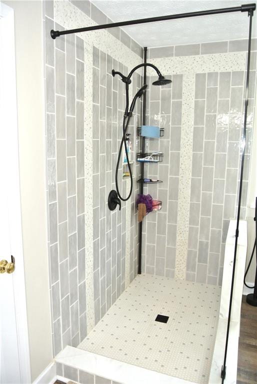 bathroom with wood-type flooring and tiled shower