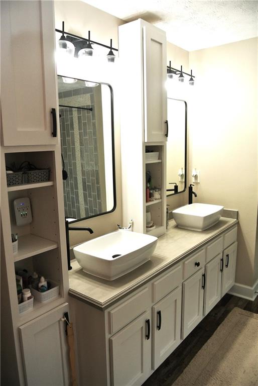 bathroom featuring a textured ceiling, a shower, vanity, and hardwood / wood-style floors