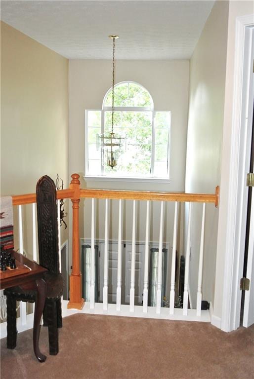 staircase featuring a chandelier and carpet flooring