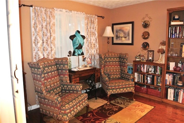 sitting room featuring wood-type flooring and a textured ceiling