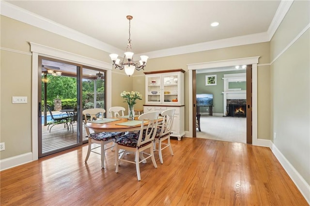 150 Henderson Farm Dr, Woodstock, GA 30188 - dining space with a high end fireplace, a chandelier, light wood finished floors, and ornamental molding