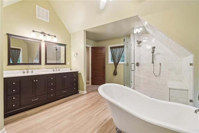 150 Henderson Farm Dr, Woodstock, GA 30188 - full bath with a soaking tub, double vanity, a shower stall, lofted ceiling, and wood finished floors