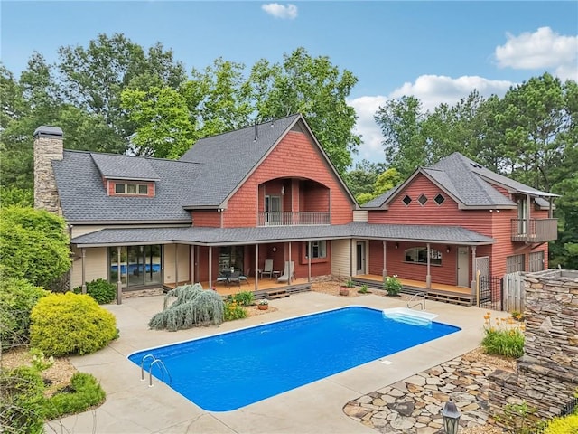 150 Henderson Farm Dr, Woodstock, GA 30188 - back of house with a balcony, a patio, an outdoor pool, a chimney, and roof with shingles