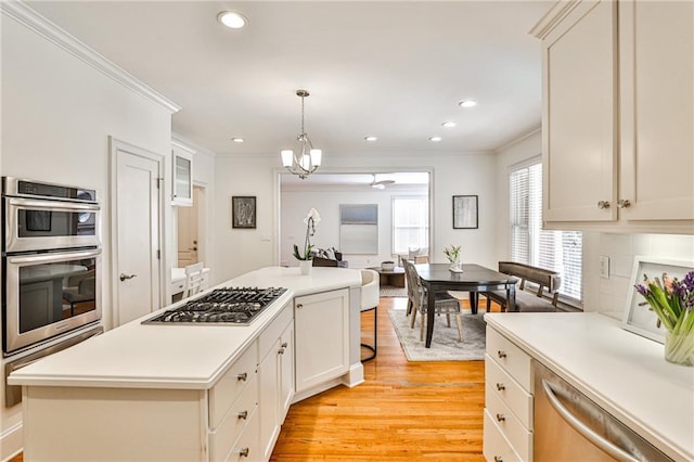 389 Mill Creek Bnd NE, Atlanta, GA 30307 - kitchen featuring light countertops, ornamental molding, light wood finished floors, and stainless steel appliances