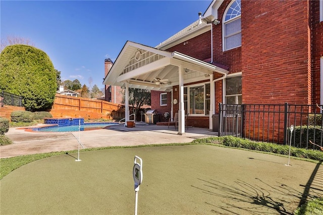 389 Mill Creek Bnd NE, Atlanta, GA 30307 - back of property featuring brick siding, a fenced backyard, a fenced in pool, a patio area, and a ceiling fan