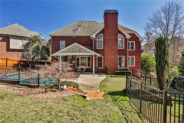 389 Mill Creek Bnd NE, Atlanta, GA 30307 - rear view of house with a chimney, a lawn, brick siding, a fenced backyard, and a patio