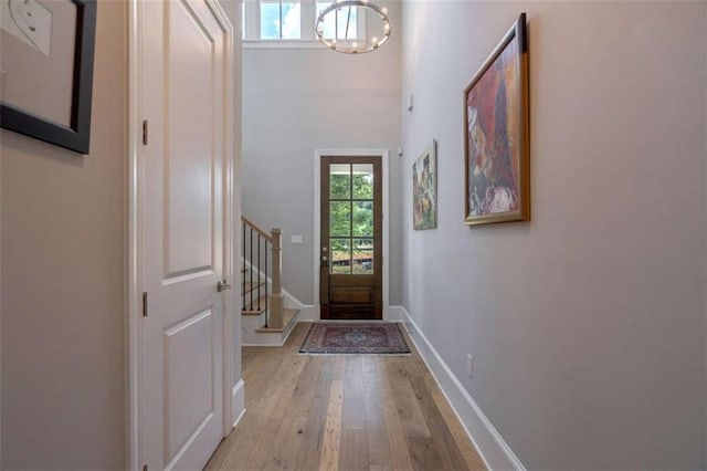 2010 Georgia Club Dr, Statham, GA 30666 - entryway featuring light wood-type flooring, stairway, and a chandelier