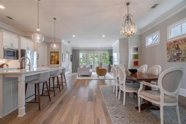 2010 Georgia Club Dr, Statham, GA 30666 - dining space featuring light wood-style flooring, healthy amount of natural light, crown molding, a chandelier, and recessed lighting