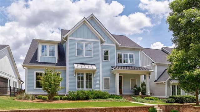 2010 Georgia Club Dr, Statham, GA 30666 - craftsman inspired home featuring board and batten siding, roof with shingles, a standing seam roof, a front yard, and a metal roof