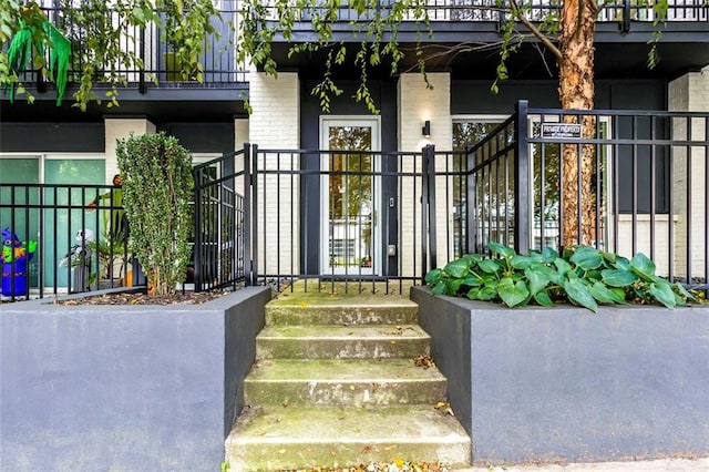 view of exterior entry with a balcony