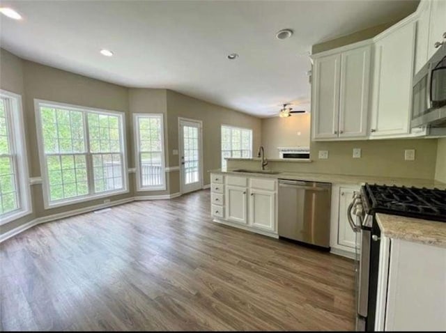 kitchen with white cabinetry, sink, kitchen peninsula, and appliances with stainless steel finishes