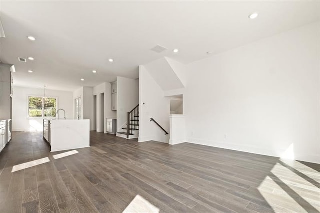 unfurnished living room with sink and dark wood-type flooring