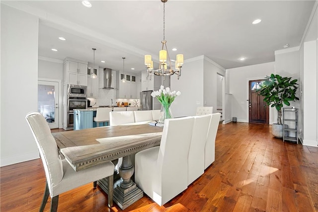 dining room featuring crown molding, dark hardwood / wood-style flooring, a chandelier, and sink