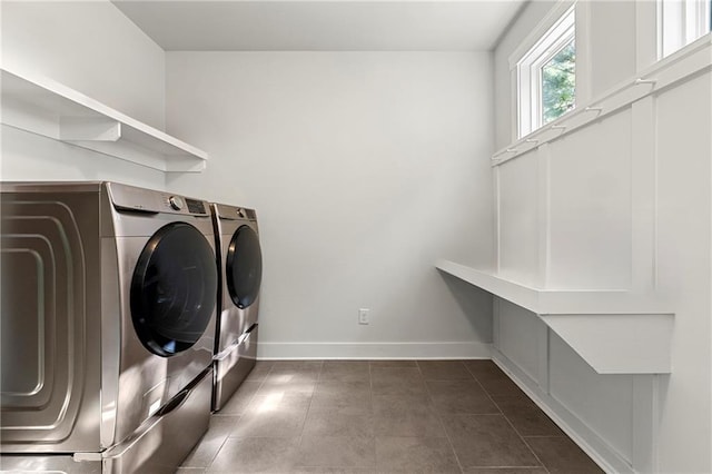 laundry area with washer and clothes dryer and dark tile patterned floors