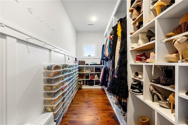 spacious closet with dark hardwood / wood-style flooring