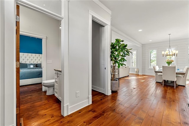 hall with dark hardwood / wood-style flooring and a chandelier