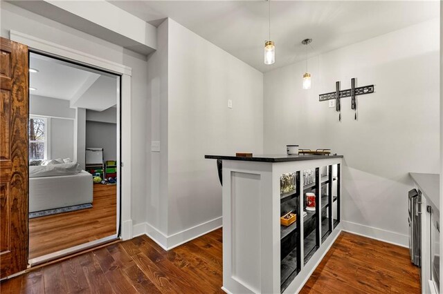 bar featuring dark hardwood / wood-style floors and hanging light fixtures